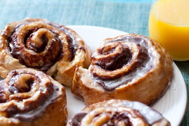 Cinnamon buns and orange juice on a blue background depicting carb and sugar limit to stay in ketosis