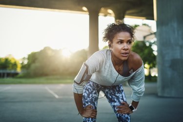 Fit woman taking a break from exercise due to heartburn