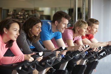 Side view of a spinning class on exercise bikes at