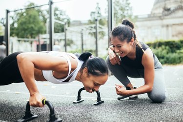 Personal trainer and woman doing fitness together.