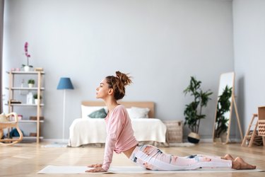 Woman yoga practicing concentration and balance exercises at home.