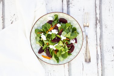 Plate of corn salad with roasted carrots, beetroots, red onions andgoat cream cheese