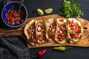 Shrimp tacos with homemade salsa, limes and parsley