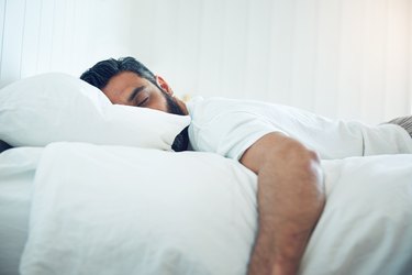 A man sleeping in bed to support his immune system