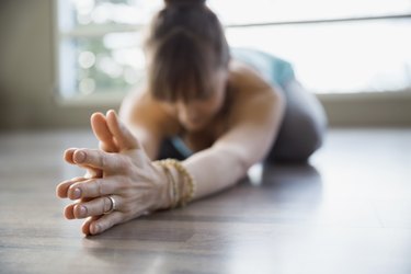 Woman in yoga childs pose with hands clasped
