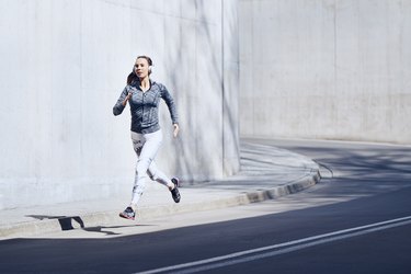 Female jogger with headphones on street