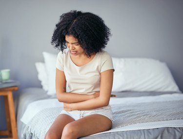 A woman with IBS holding her stomach in pain