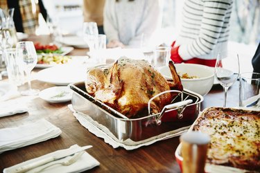 Turkey in roasting pan on table for holiday meal