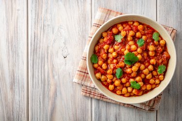 Spicy Chickpea curry Chana Masala in bowl on wooden table