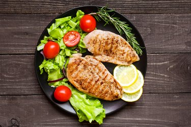 chicken grilled breast fillet with herbs, vegetables and lemon