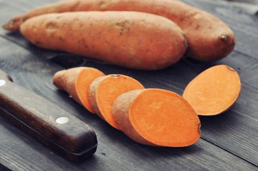 Jewel sweet potato slices on wooden table.