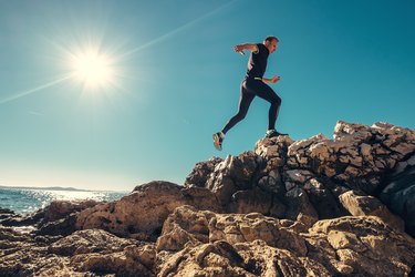 a person with strong hamstrings running up a rocky trail