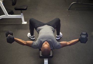 Man in the gym doing dumbbell chest flyes