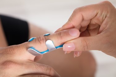 Physician Holding Person's Finger With Brace