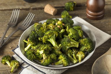 Organic Green Roasted vitamin k-rich Broccoli Florets in bowl on wooden table