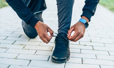 Man tying shoelaces preparing to run outside