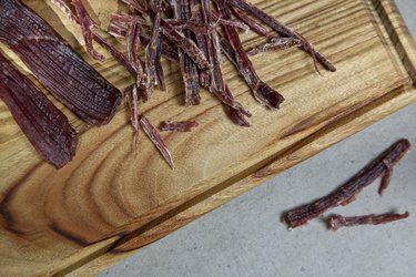 Close up shot of homemade shredded beef jerky on wooden cutting board