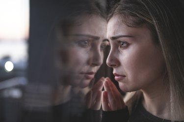 不开心的女人在窗前哭泣