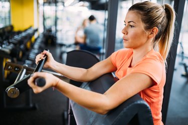 Young beautiful woman doing exercises for biceps