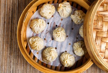 Freshly cooked dumplings inside of bamboo steamer ready to eat