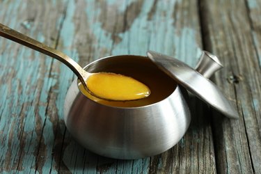 Ghee /  Clarified butter on rustic blue background, selective focus