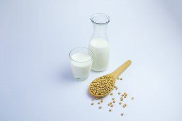 Milk with soy beans on white background
