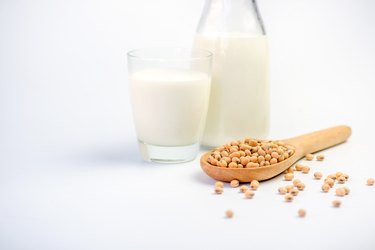 Milk with soy beans on white background