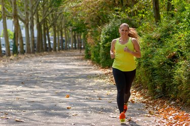 Determined middle-aged woman jogging in the park