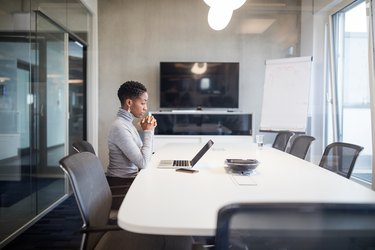 Businesswoman sitting at conference table with on laptop