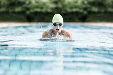 Young woman swimming in swimming pool, breast-stroke swimming