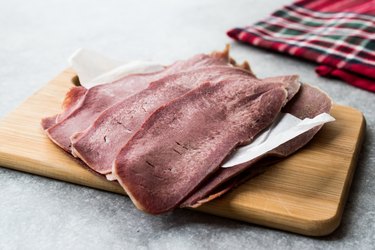 Sliced Beef Tongue Slices on Wooden Board.