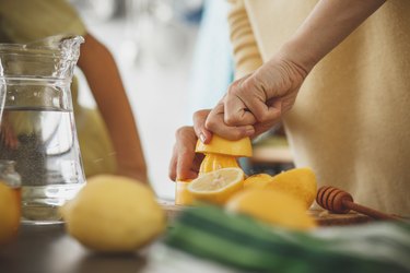 Woman making lemon water, a food that is bad for teeth