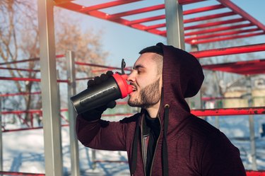 Sporty man drinking protein cocktail after workout