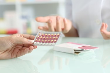 Hands holding contraceptive pills