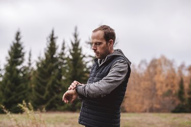 Man with fitness tracker walking outdoors in nature