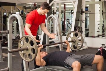 Young man spotting each other in a gym