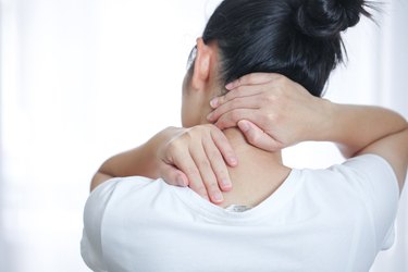 Woman with her hands around the back of her neck