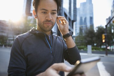 Man using competitive fitness app on smartphone outside