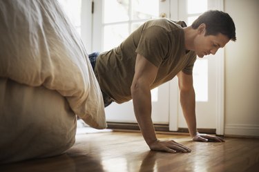 Man doing push-ups in bedroom at home