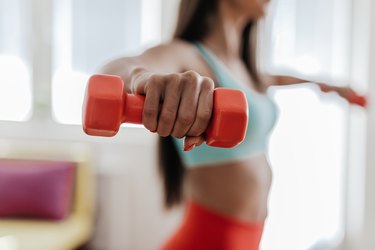 Young woman exercising with her weights in the living room