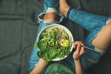 素食早餐碗菠菜、芝麻菜、鳄梨、种子和芽甘蓝