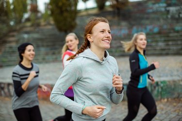 Fit woman with friends jogging in park