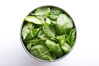 Directly Above Shot Of Spinach Leaves In Container Over White Background