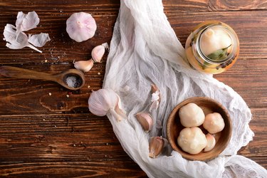 Composition with tasty fermented garlic on wooden table