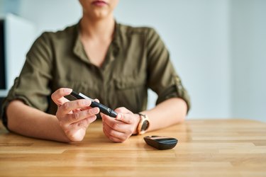 Woman checking her glucose level reading for normal blood sugar in the morning