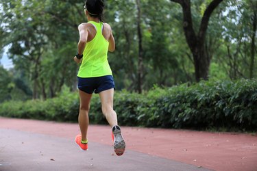 Fitness sporty woman jogger running at outdoors jogging track in park