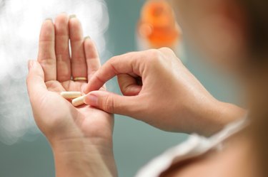 Young woman taking vitamins thinking about cutting it