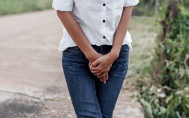 woman with hands holding her crotch because she has a sweaty vagina