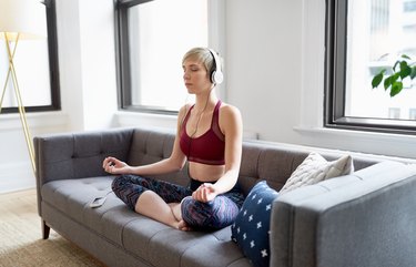 Trendy woman listening to a meditaion app as part of her mindfulness morning routine