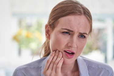 Woman in pain holding the right side of her jaw